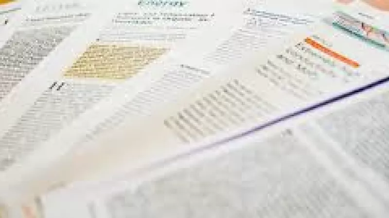 The image shows several printed scientifc journal articles arrayed on a desk.