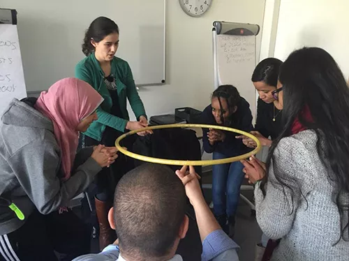 students in a class holding a hula hoop together