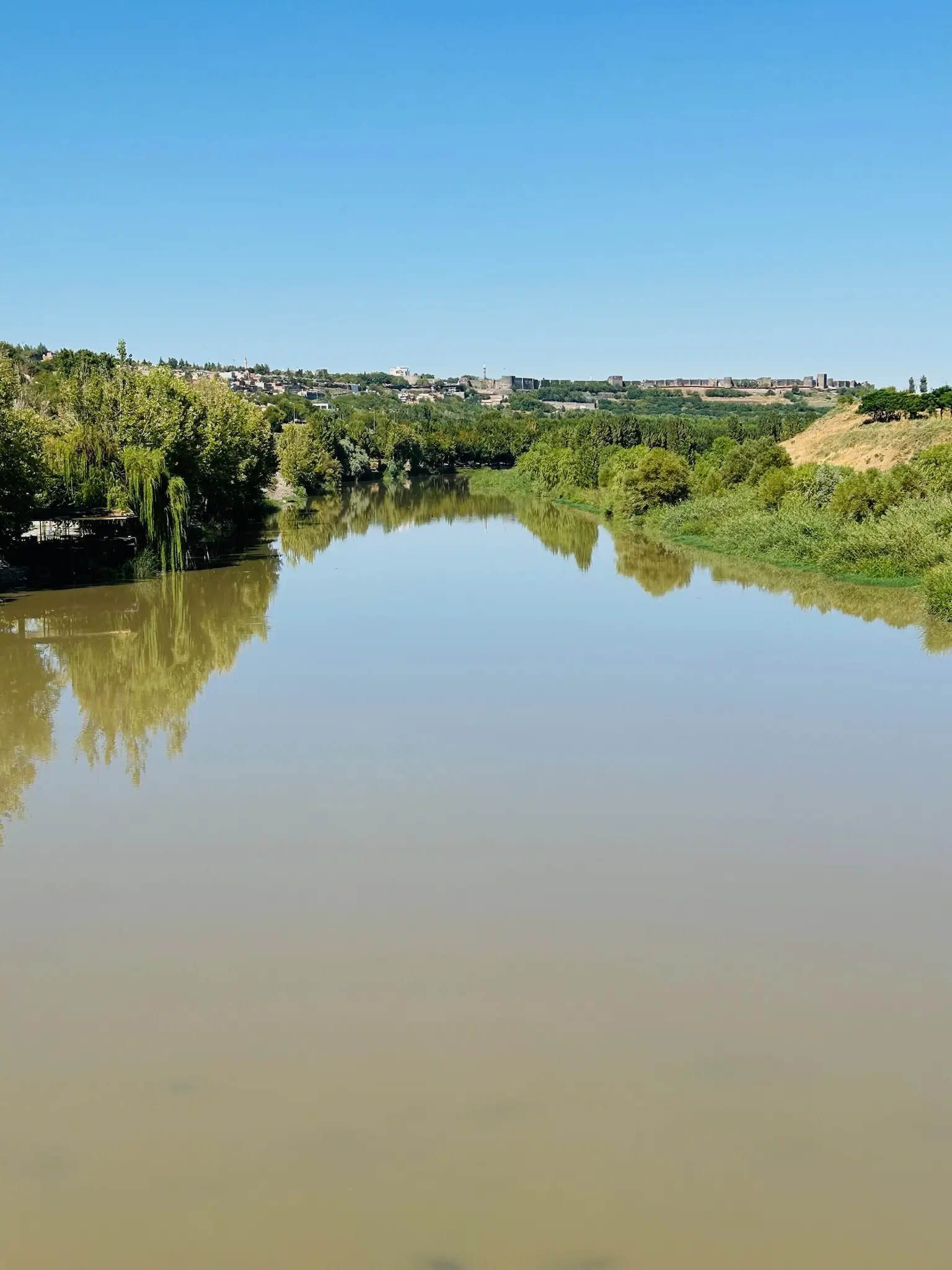A photo of a serene river with old city walls in the background