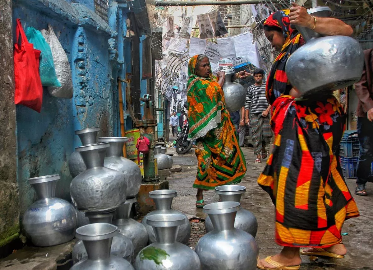 women carrying containers of water